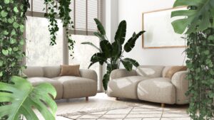 Spacious room with modern grey couches surround on all side with indoor plants. 