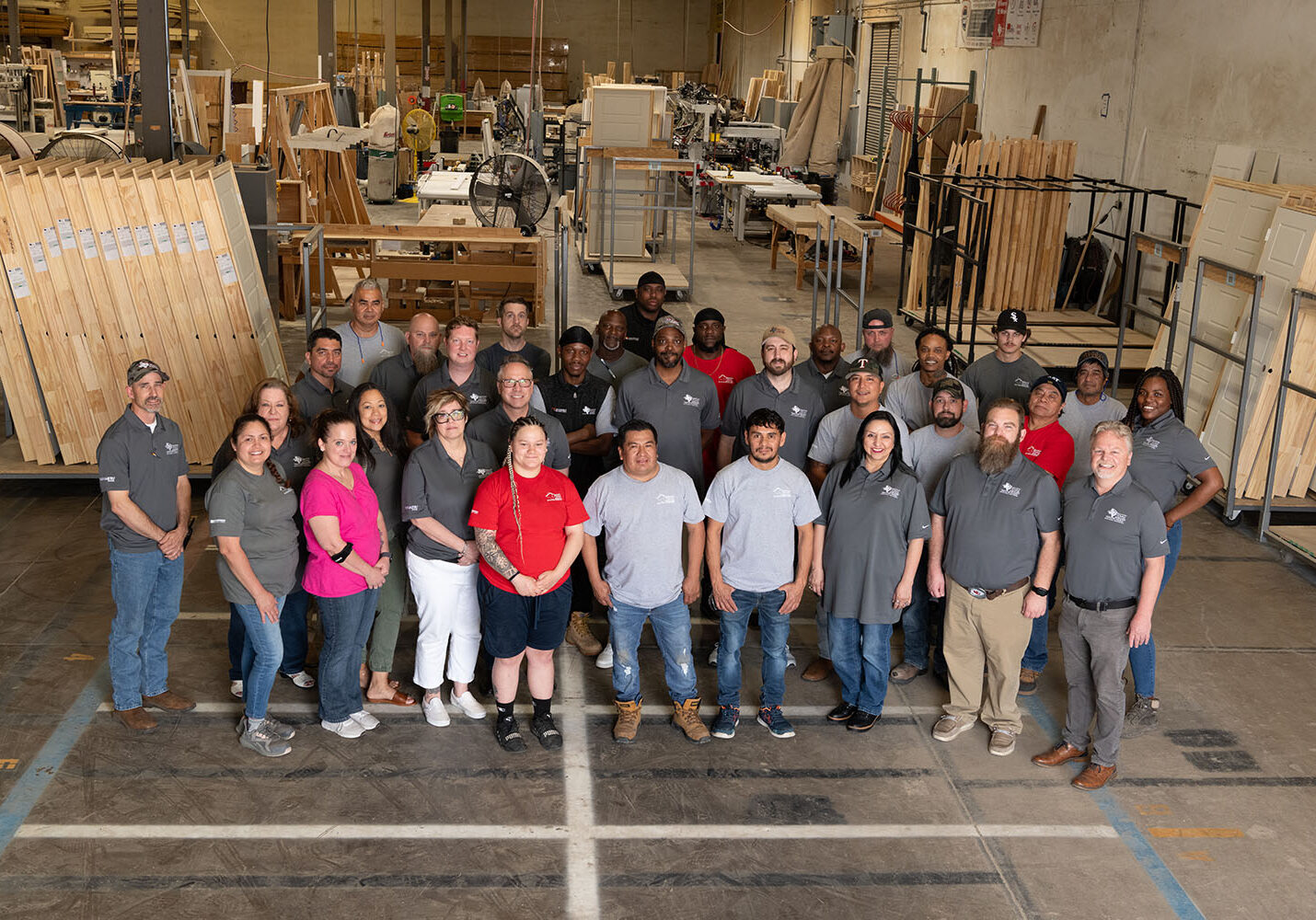 Group of employees standing together for a picture inside a warehouse.