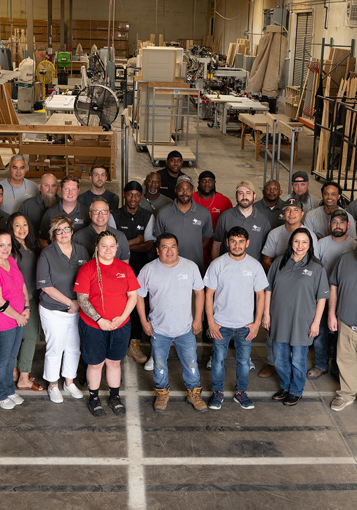 Group of employees standing together for a picture inside a warehouse.